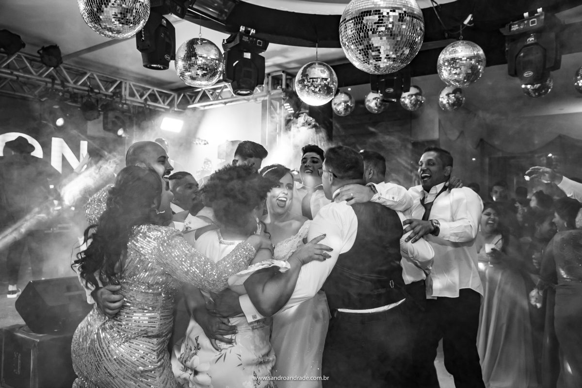 Os noivos no meio de um grupo, todos abraçados, pulando e cantando, se divertiram muitoooo. Elinete e Diego são muito família, por isso escolhemos essa imagem para finalizar este álbum, com todos juntinhos e se divertindo.