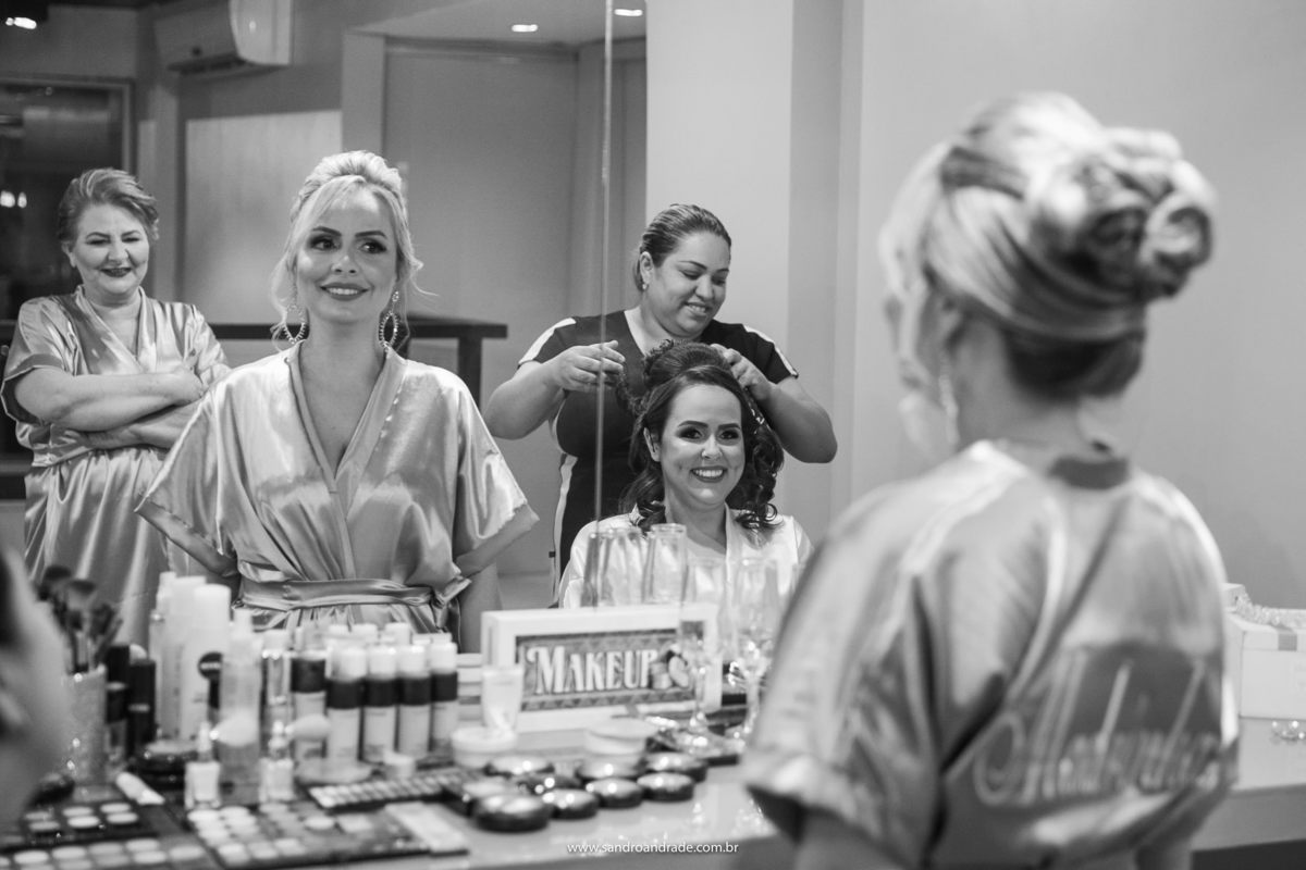 Enquanto a noiva está fazendo o penteado, sua irmã pede opinião sobre seus brincos.