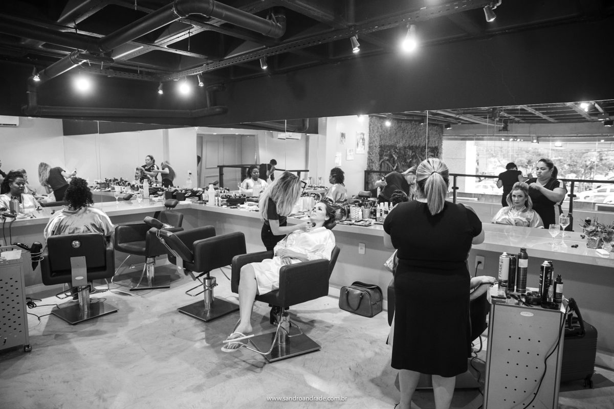 Uma imagem do salão, mostrando a noiva e suas madrinhas sendo maquiadas.