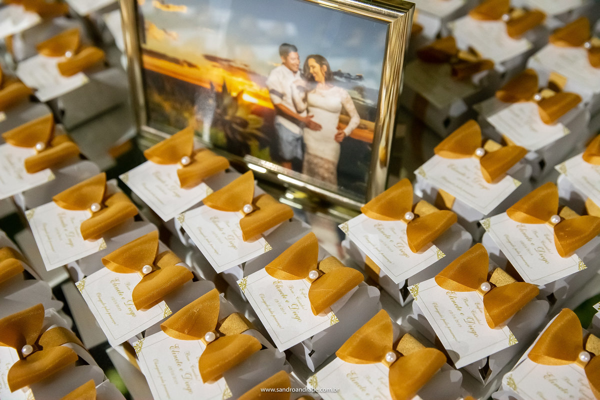 Um porta retrato com a foto do casal em meio aos bem casados.