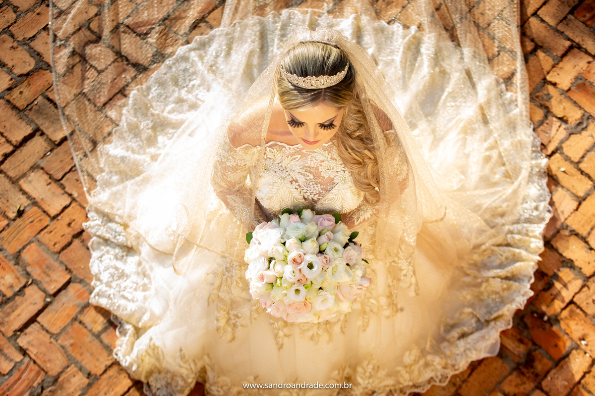 Sandro Andrade é um fotógrafo completo, ele vai do tradicional ao inusitado e de um olhar único, de cima do para peito ele faz esta foto da noiva, com o vestido todo aberto e de cima para baixo com todo o contraste rústico dos tijolinhos. Fotógrafo de BSB