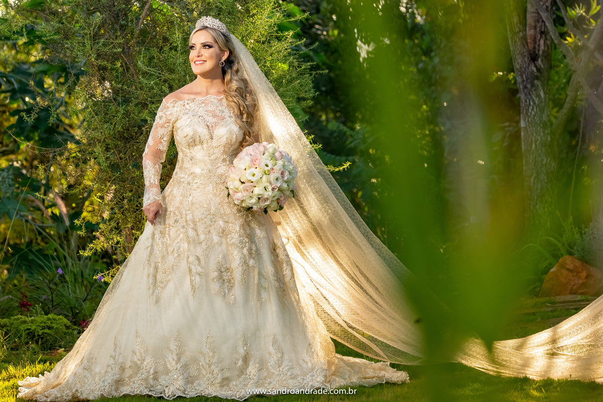 Ainda no jardim, porem agora segurando o vestido e o buque.