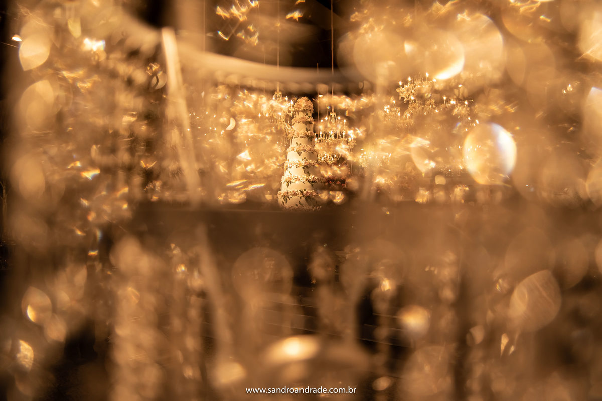 O bolo entre os cristais dos lustres, uma linda dupla exposição feita por Sandro Andrade um dos melhores fotógrafos de casamento de Brasília.