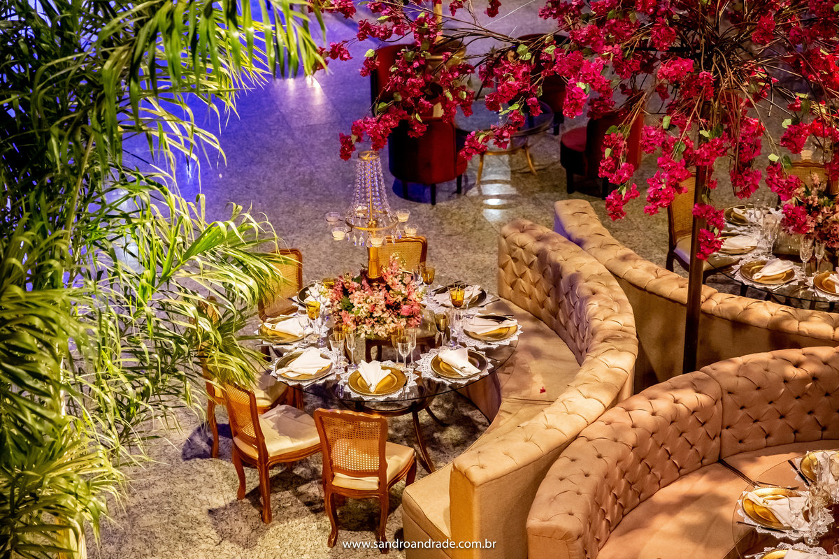 Um detalhe da árvore colorida com os lounges e mesa de convidado, de fundo as luzes da boate.