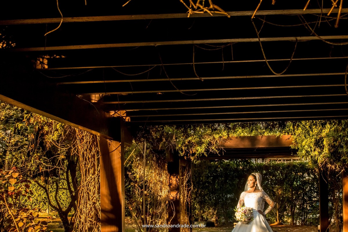 Imaginando como será no dia do seu casamento, ela faz o percurso que fará no caminho até o altar, com luz natural e buque na mão, fotografia minimalista.