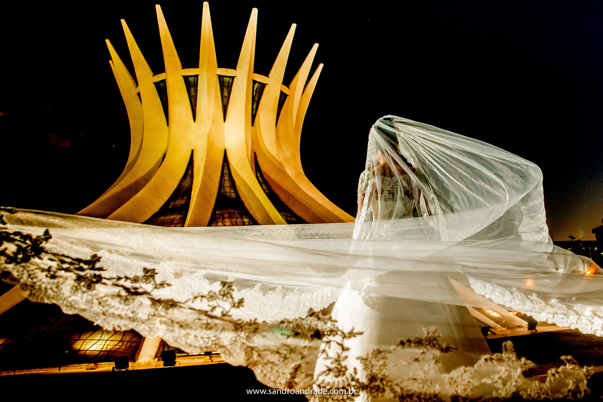 Para tudooooo, que foto linda, colorida, a catedral em toda iluminada em tom de amarelo, a noiva está de costas, com o véu voando.