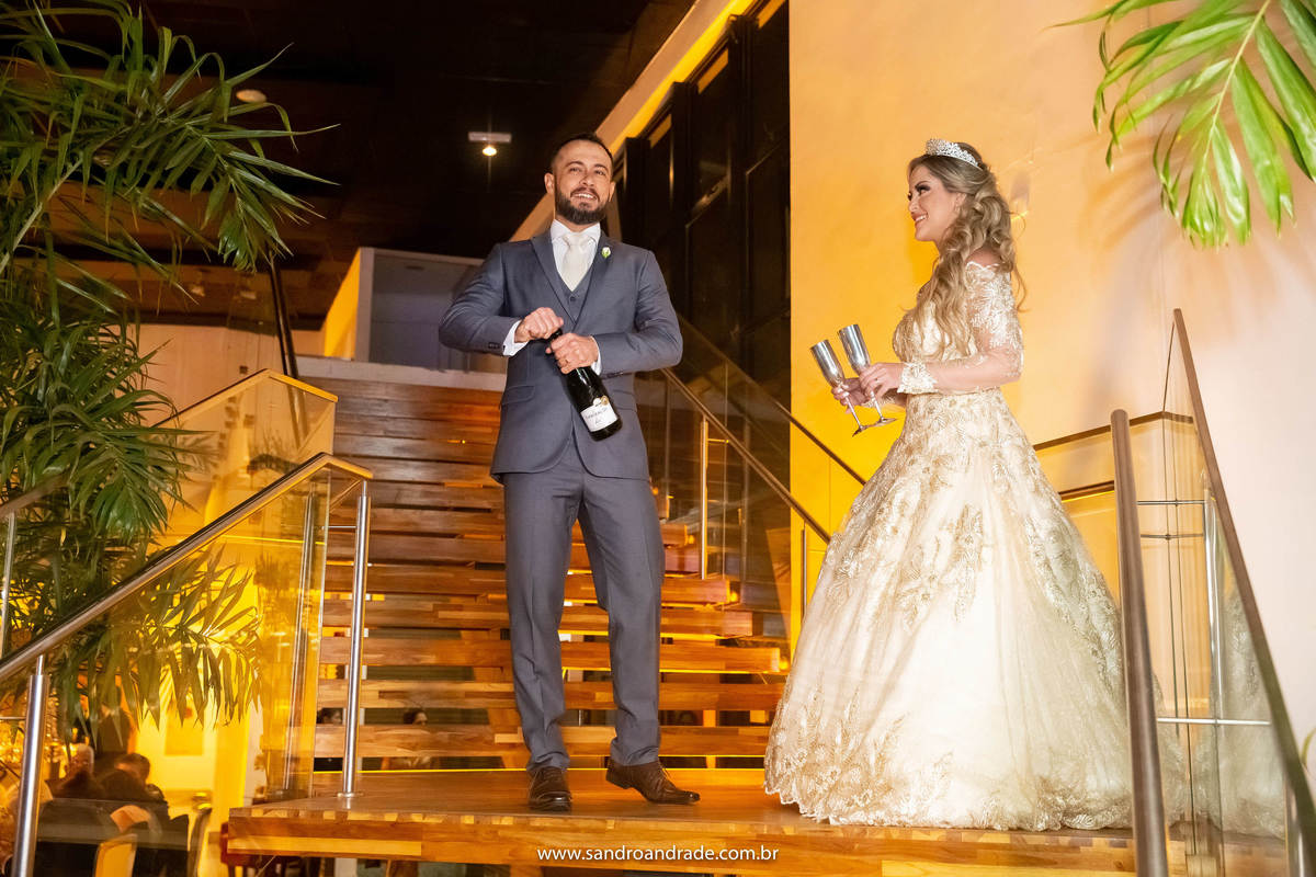 Na chegada da festa, Cassia e Rafael param na escadaria do Unique Palace para estourar o champanhe.