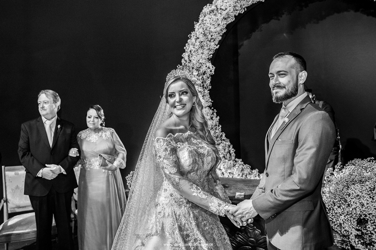 Felizes eles estão de mãos dadas aguardando a chegada das alianças.