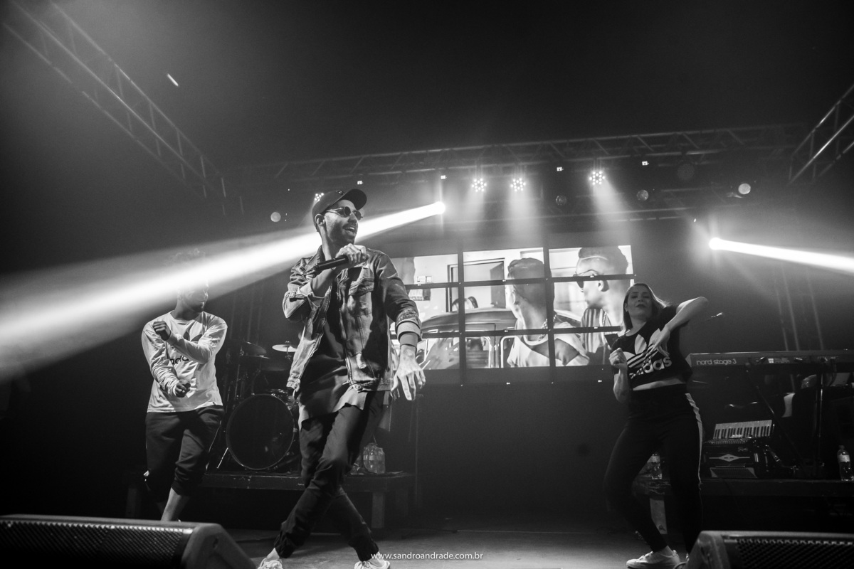 O dj e os dançarinos fazendo uma coreografia.