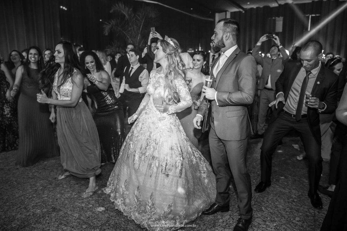 O casal na pista de dança em meio aos amigos.