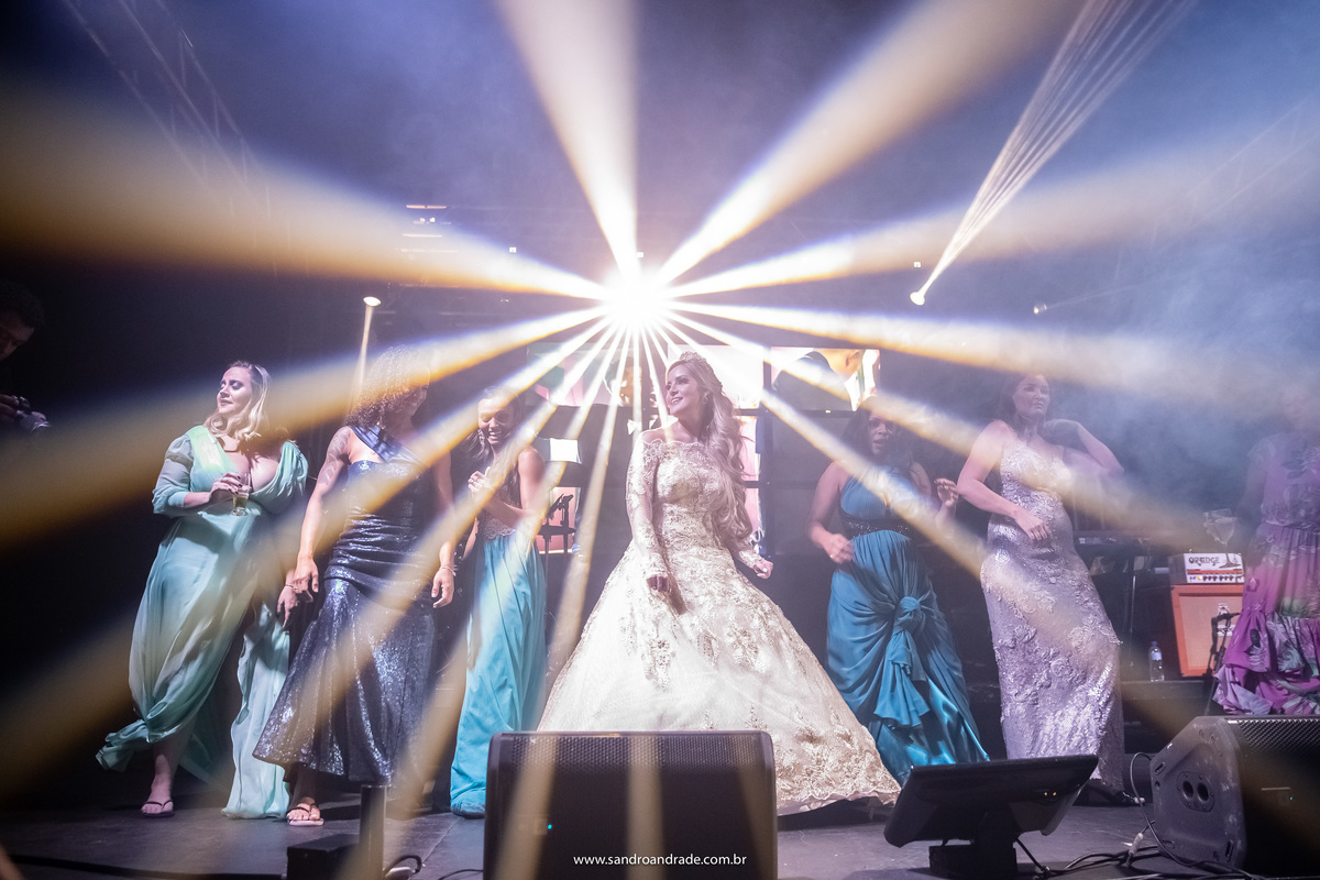 Uma linda fotografia com o jogo de luz da banda, nosso artista Sandro Andrade é um fotógrafo completo. A noiva e suas amigas no palco da banda.