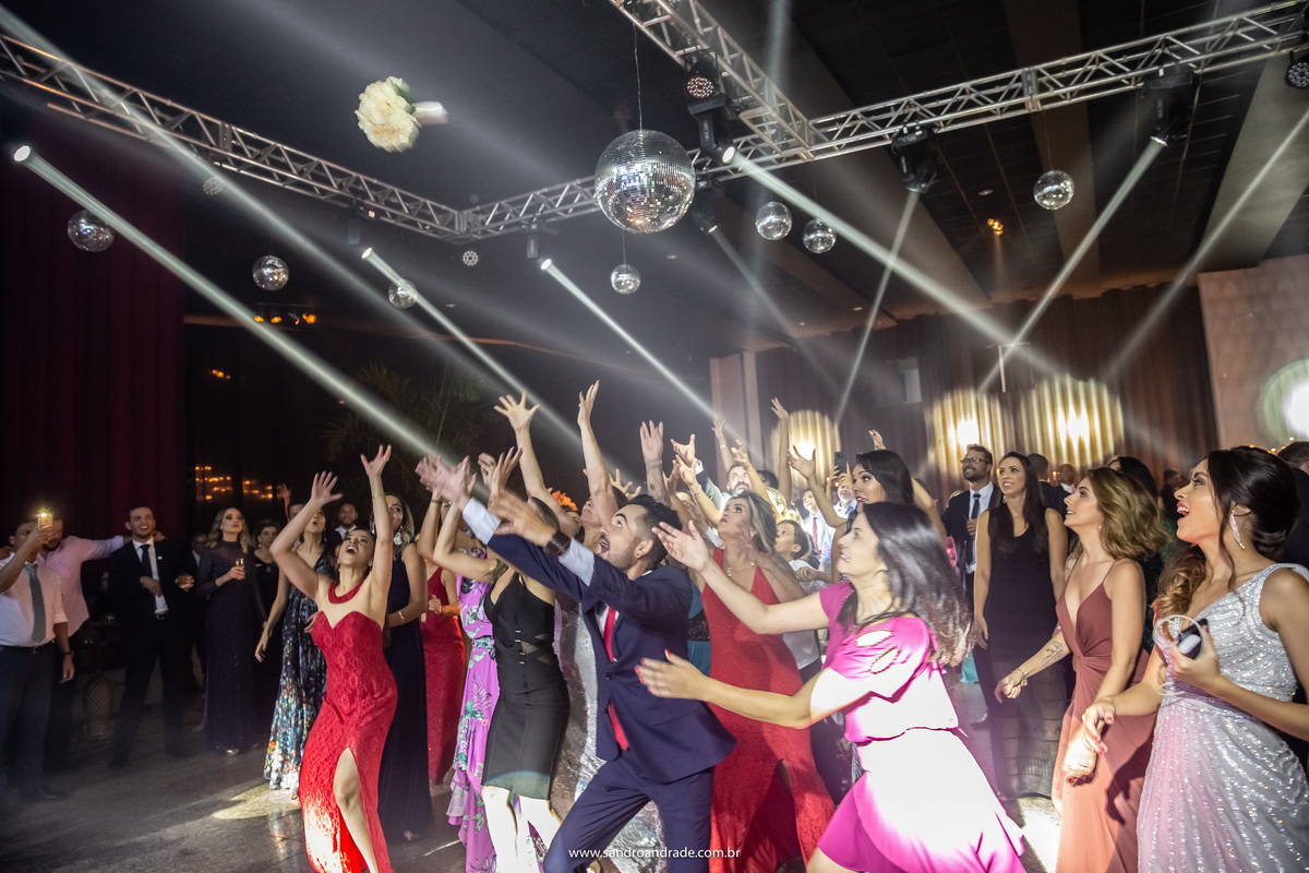 As solteiras tentando pegar o buque e entre elas um solteiro.