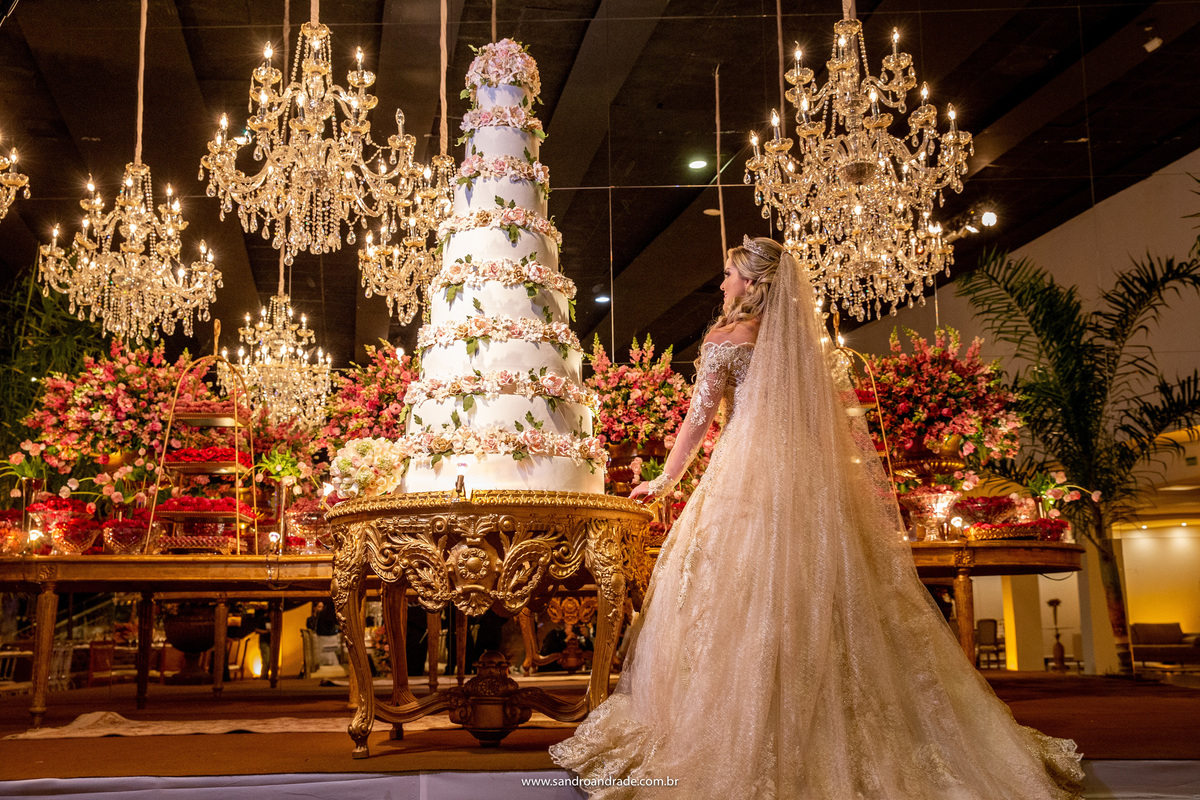 Uma linda fotografia da noiva de costas na mesa do bolo.