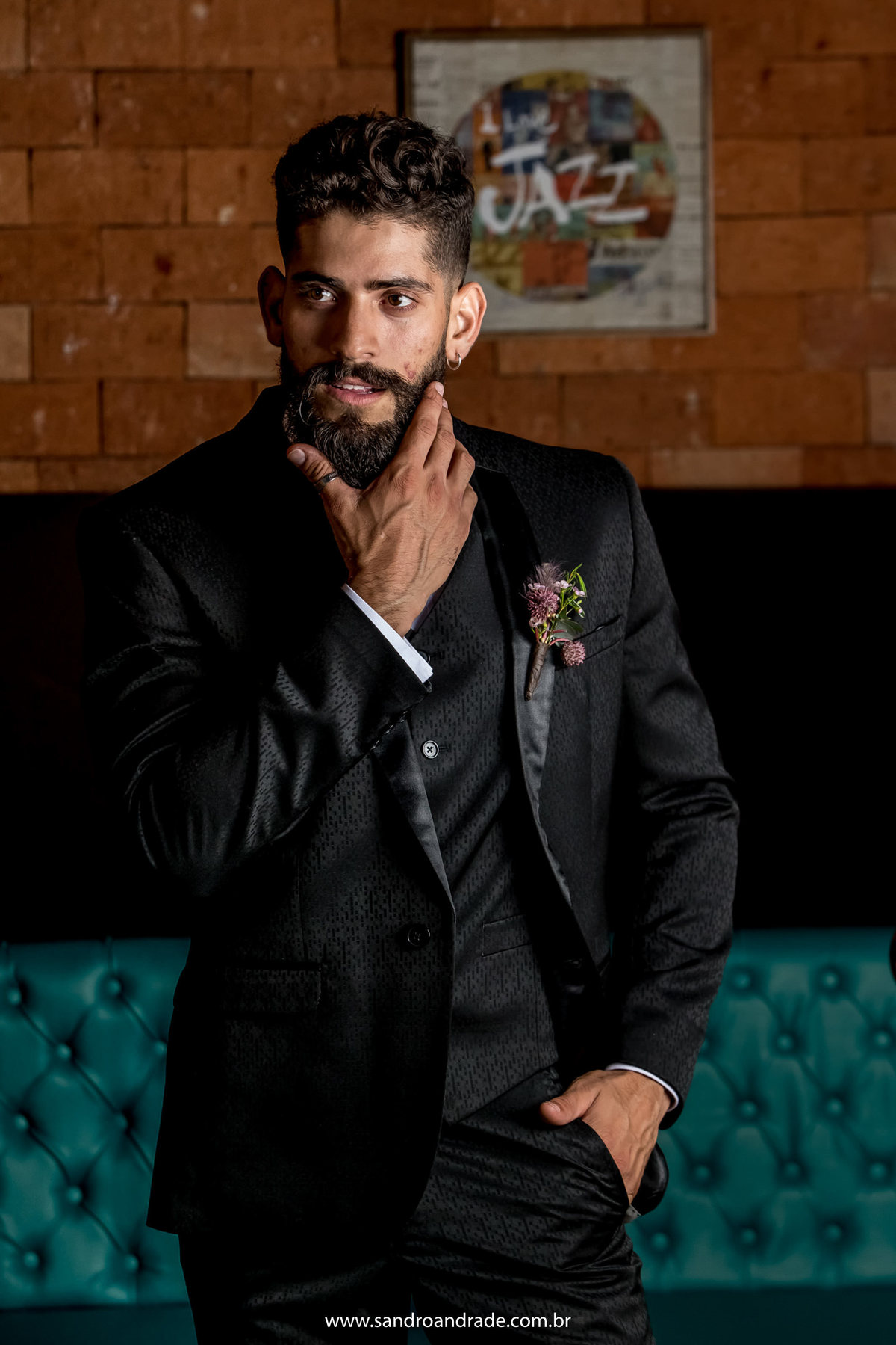 Modelo posando com a mão na barba.