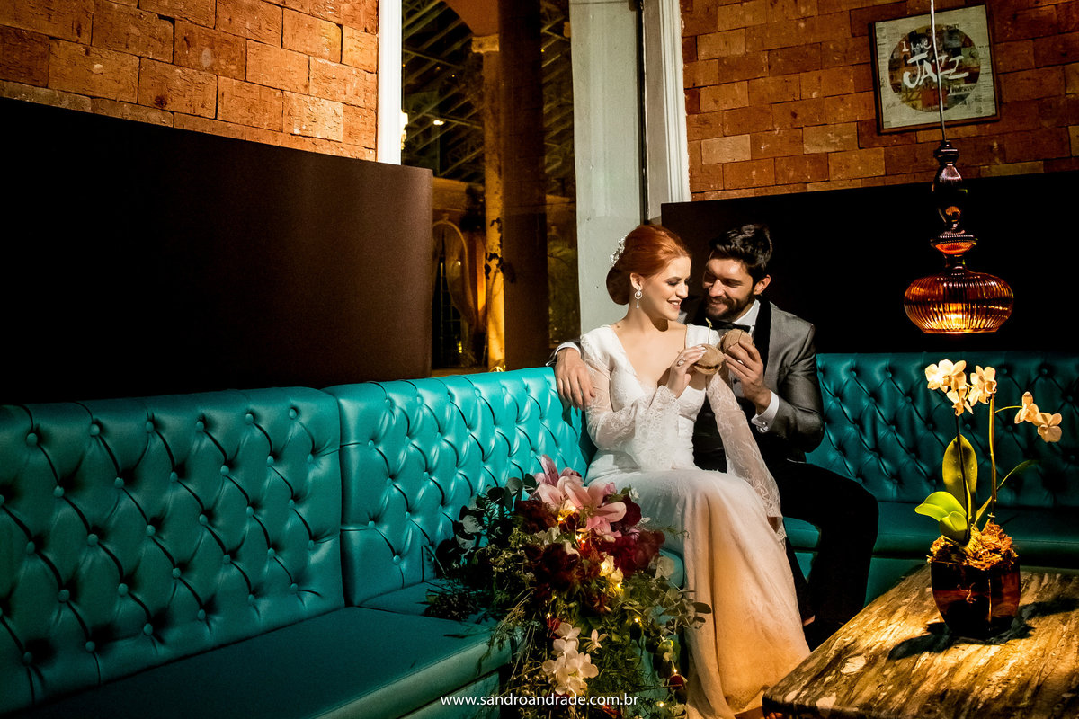 Após a troca de roupa os modelos noivos, sentados no lounge da boate, com mini hambúrgueres nas mãos.