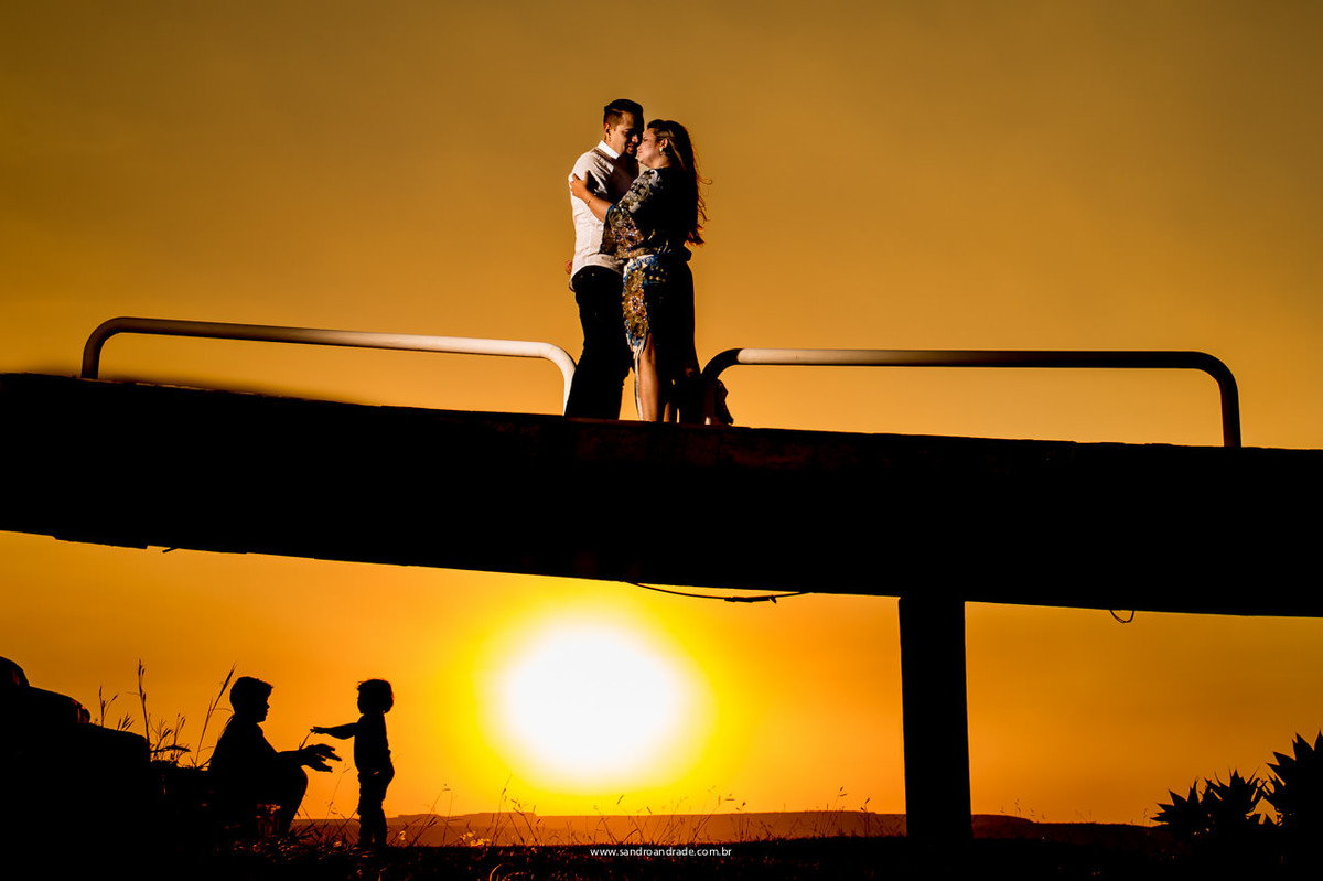 Jaqueline e Sidiel com seus lindos filhos brincando ao fundo em uma linda silhueta