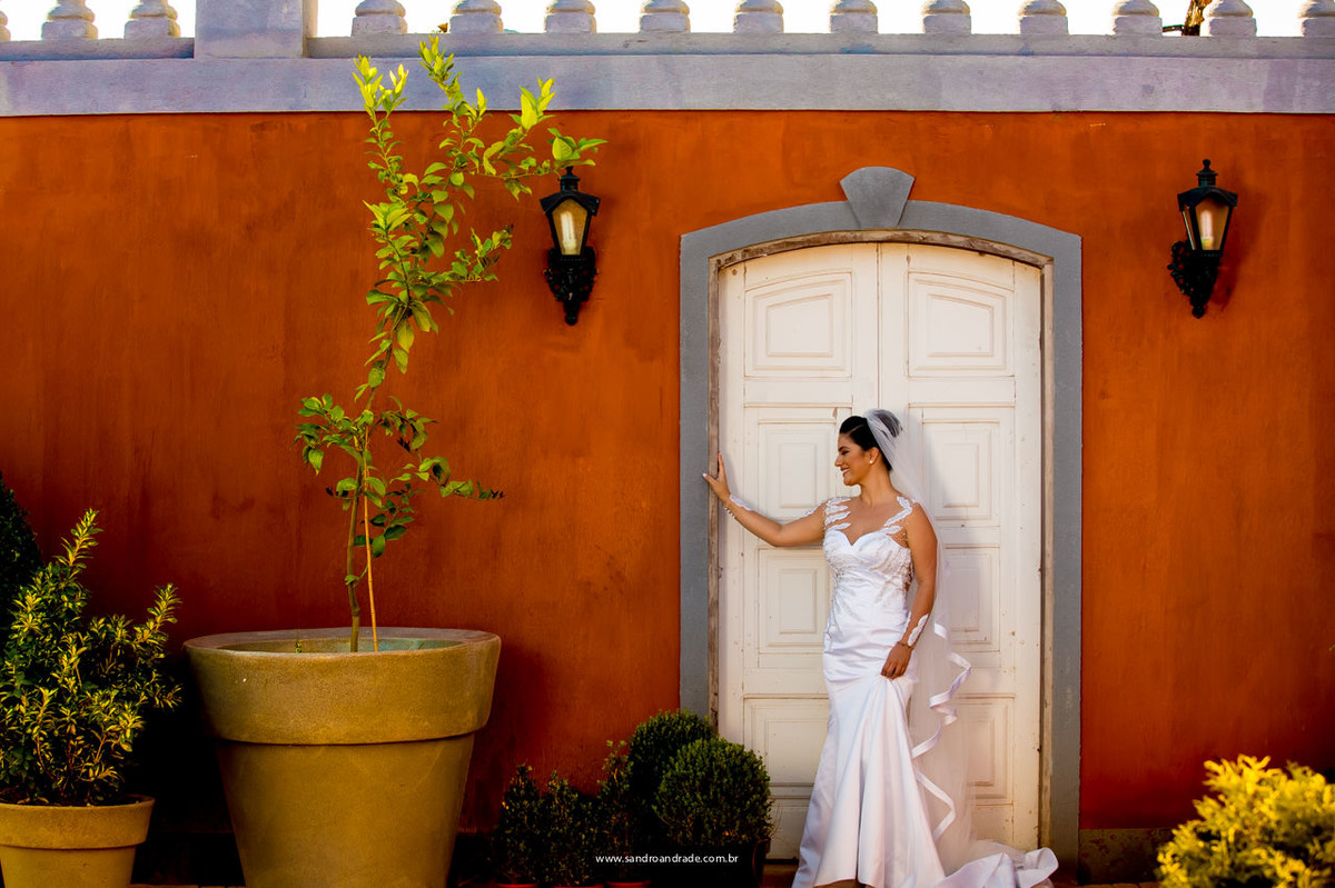 contraste do vestido branco de noiva com a cor da parede, click feito por sandro andrade fotografo de casamento em bsb