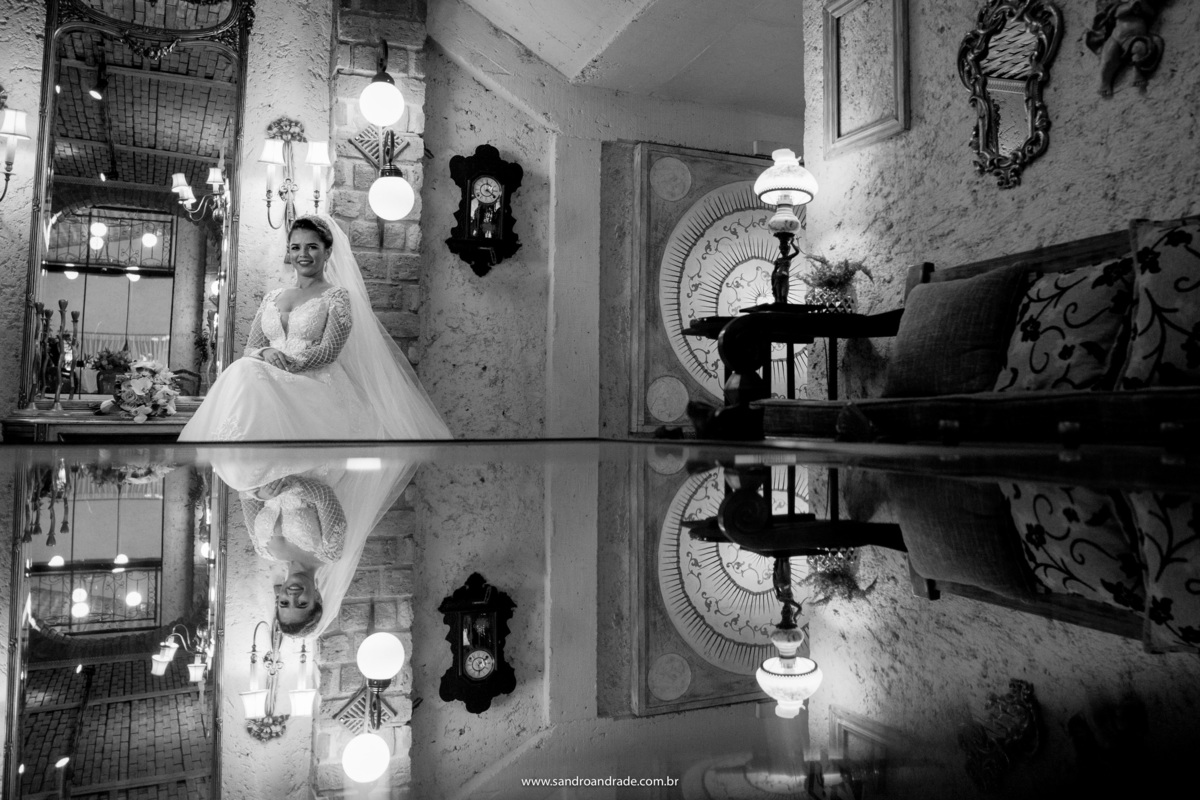 Uauuuuu...que foto e que reflexo, Sandro Andrade é um dos melhores fotógrafos de Brasília e não é a toa, essa fotografia está maravilhosa, a noiva esta sentada no salão principal com toda a decoração e seu reflexo está na mesinha de centro.