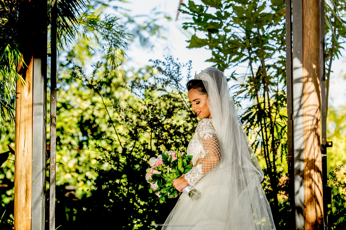 A noiva Flavia escolheu o local onde irá casar para a locação de sua prévia de noiva, em um belíssimo vestido de noiva do atelier Fernando Peixoto. No portão de entrada, ela está um pouco de costas, olhando seu lindo buque de noiva.
