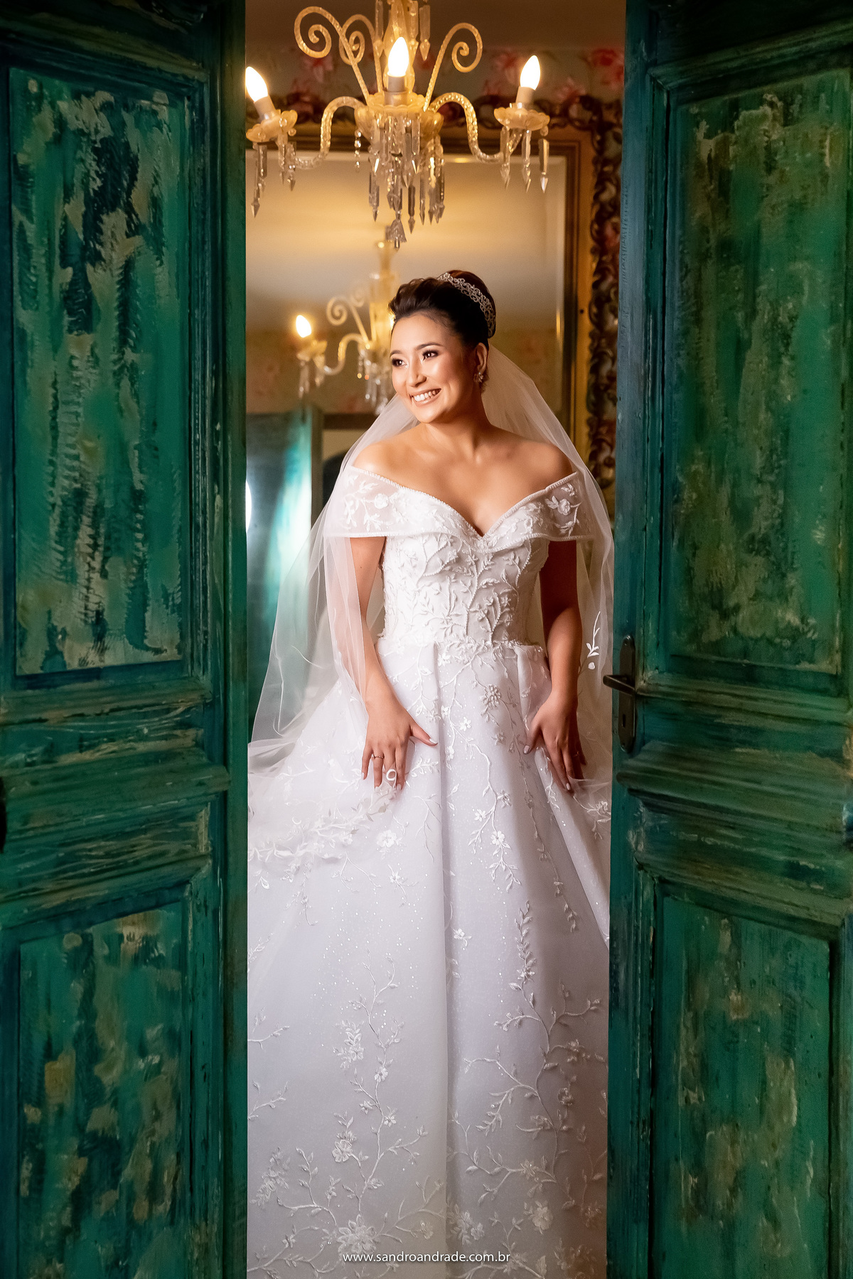 Enquanto aguarda o amor de sua vida, o fotógrafo Sandro Andrade aproveita para fazer mais fotos da noiva, nossa primeira novinha descendente de japonês. Dany está dentro do quarto dos noivos e com a porta entre aberta, temos o contraste da cor da porta.