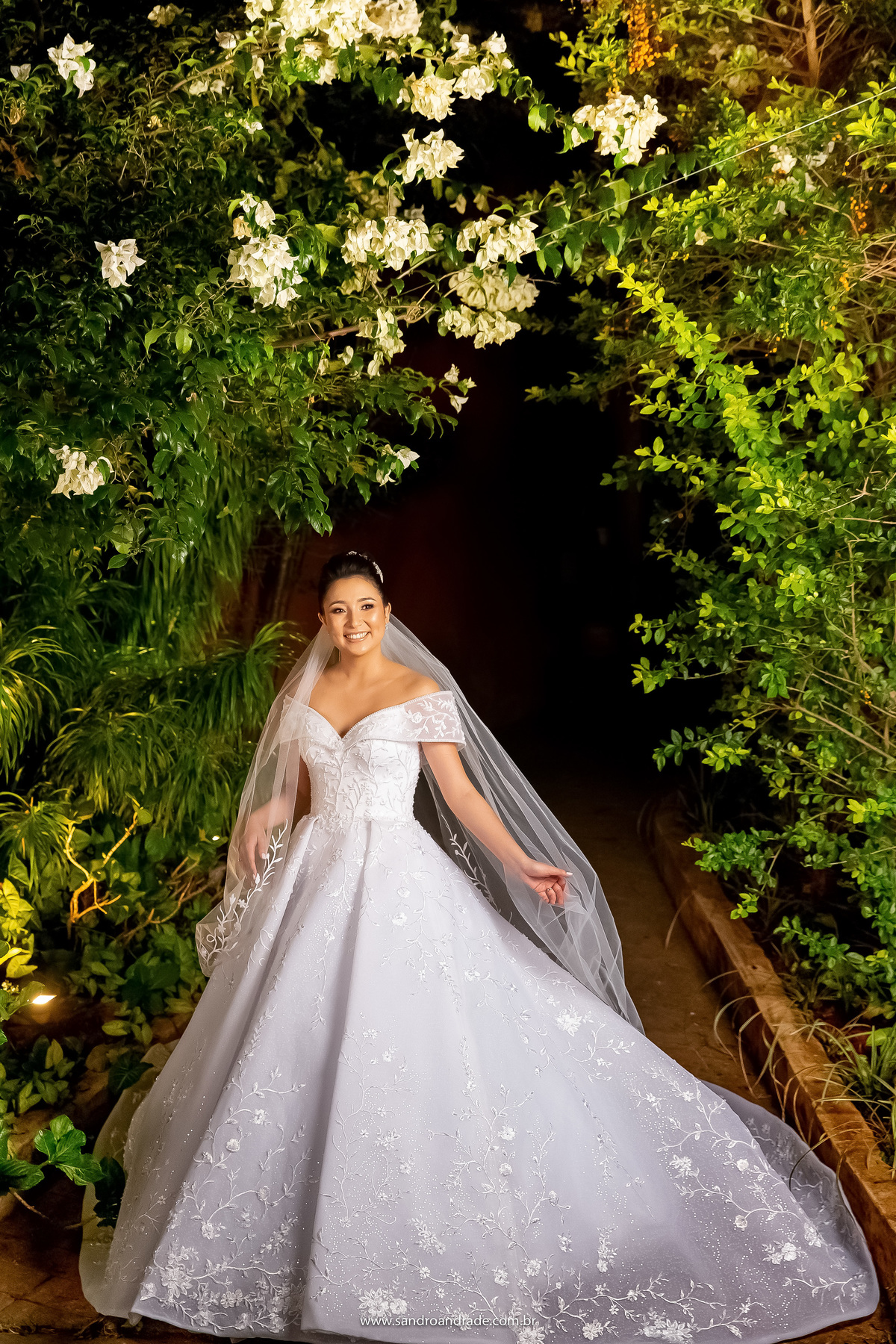 Em um caminho que ninguém veria nada, Sandro Andrade enxerga varias oportunidades de fotos diferentes, com lindas composições e um olhar único. A noiva está em um caminho escuro, mas com a iluminação correta conseguimos esta linda fotografia espontânea.