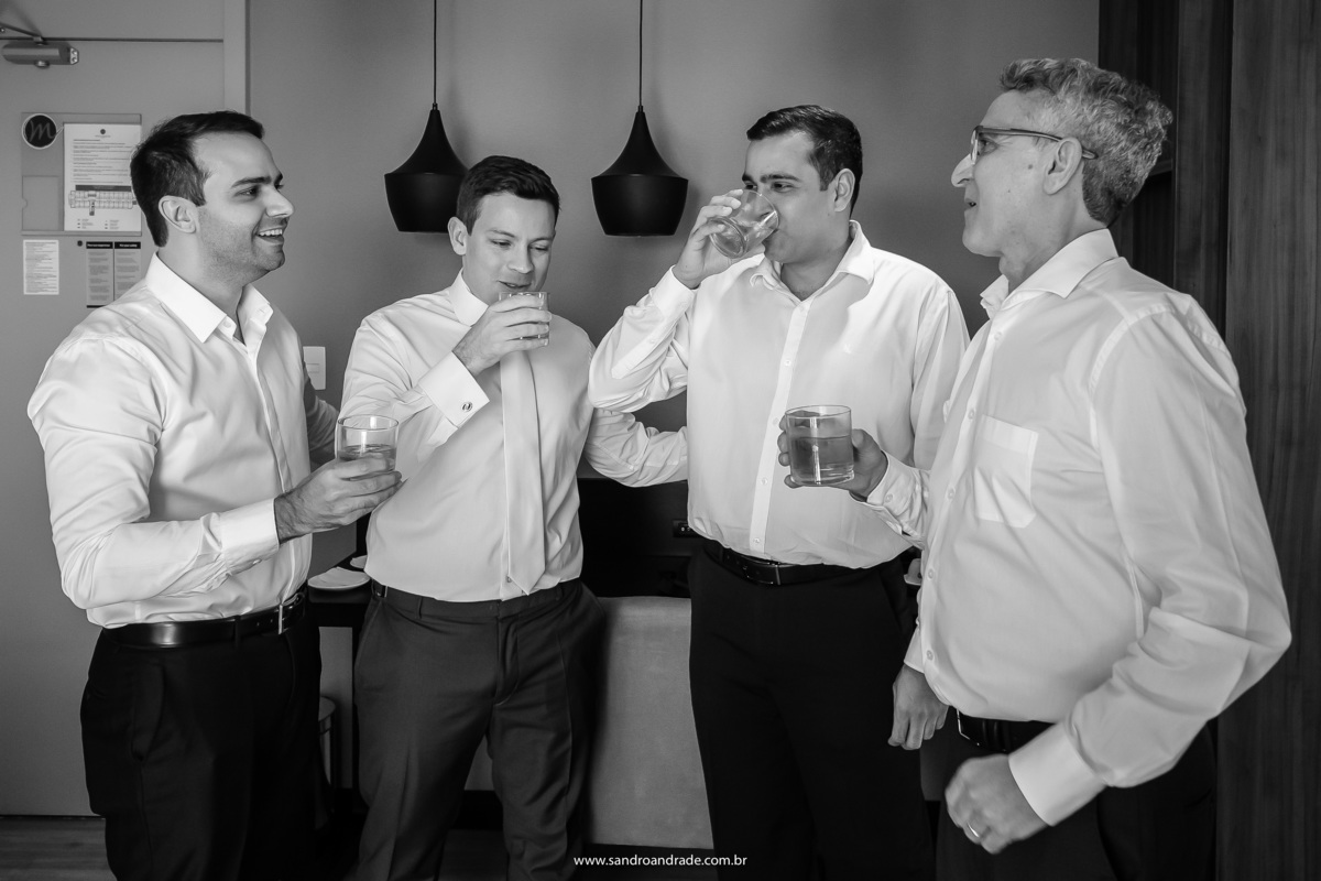 Um brinde entre o noivo, o pai e seus dois irmãos antes do grande momento.