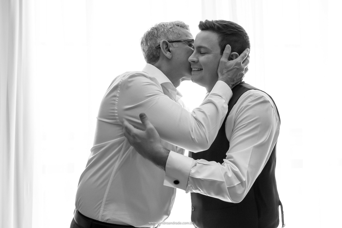 Um carinho entre pai e filho, com um beijo no rosto o pai do Murilo deseja felicidades ao seu filho.