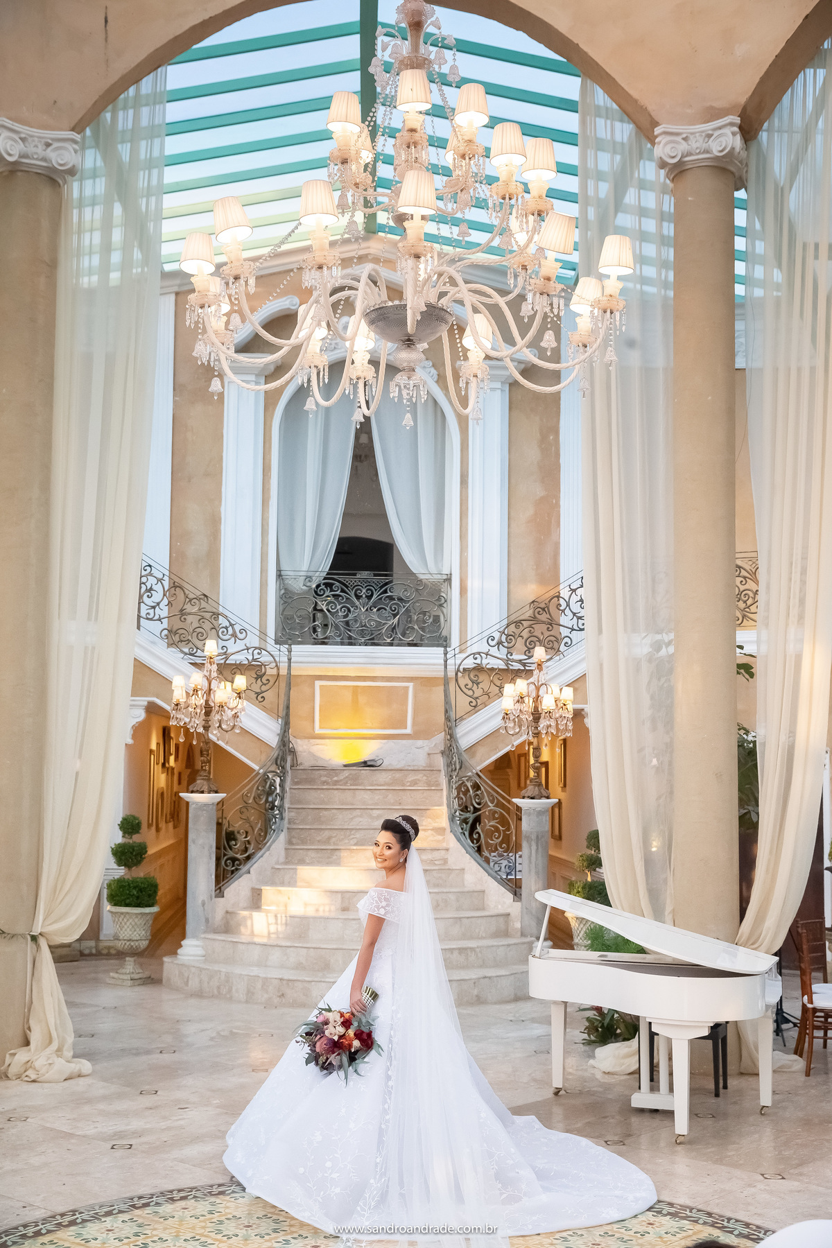 A noiva muito feliz e com seu buque, está de costas na frente das escadas do pallazo, sorrindo para as lentes de seu maravilhoso fotógrafo Sandro Andrade um dos melhores fotógrafos de casamento de Brasília.