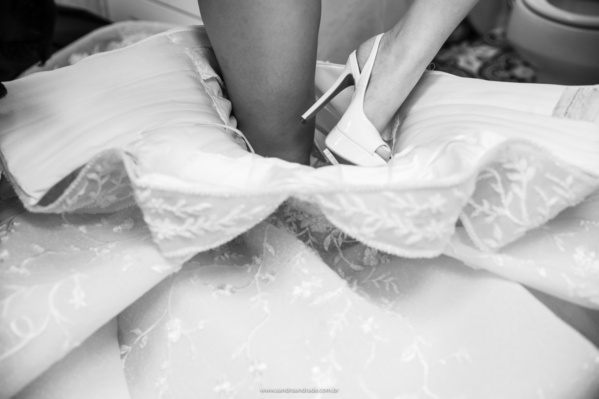 Mais um detalhe, a noiva está vestindo seu belíssimo vestido de noiva do atelier Cristiano Bernardes. Nesta fotografia mostra o pé já de sapato, entrando no vestido.