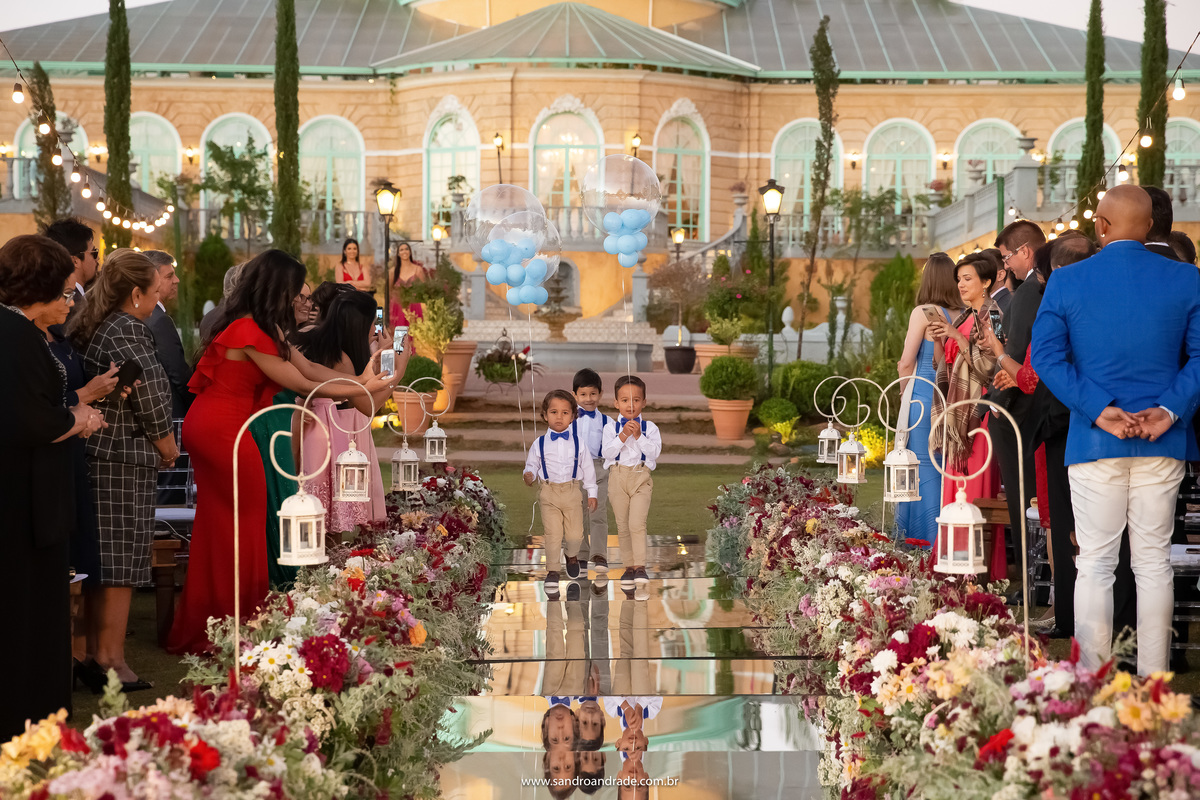 Uma fotografia colorida maravilhosa, pegando todo o pallazo da Villa Giardini na entrada dos pajens, que estão entrando com balões de gás transparente e azul.