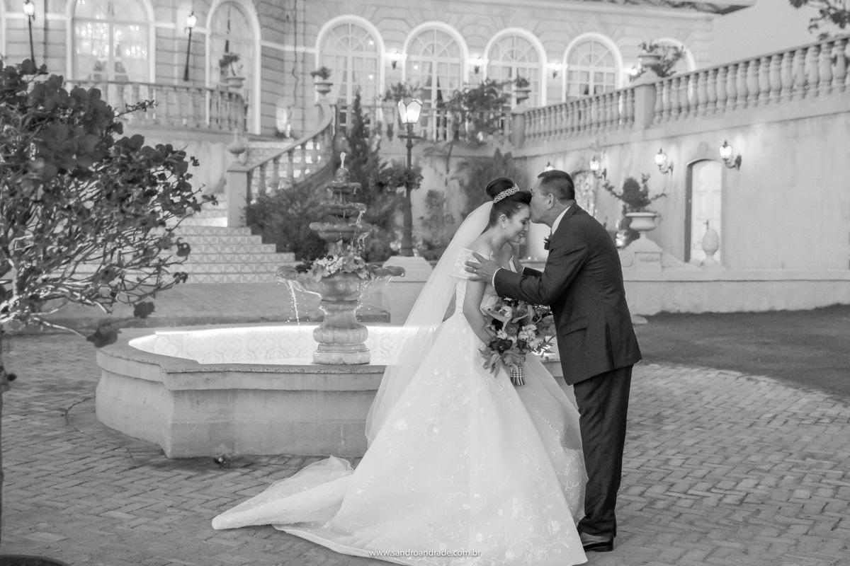 Uma linda fotografia preto e branco, o pai recebido sua filha com um beijo na testa, ela está uma princesa.