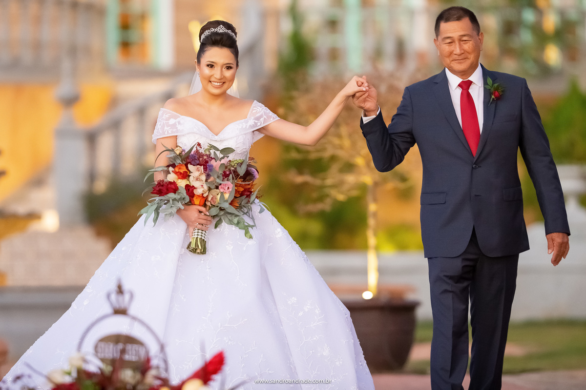 De mãos dadas e felizes, pai e filha estão a caminho do altar.