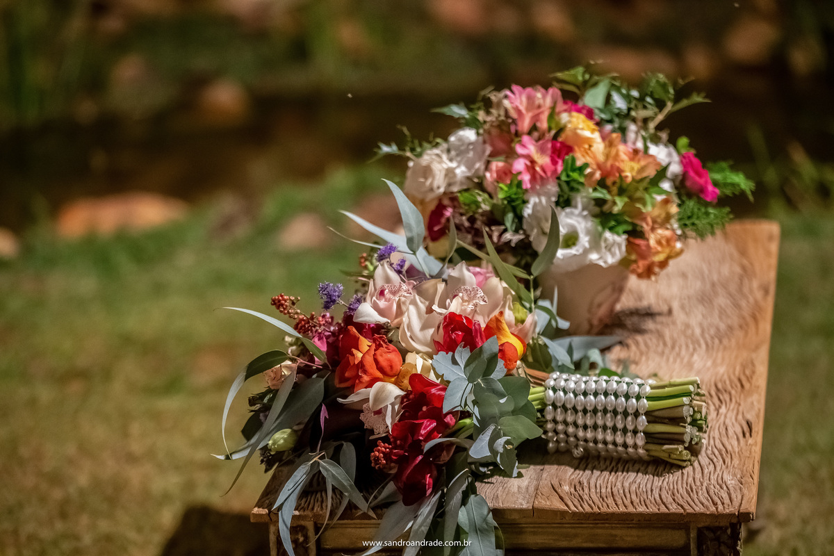 Detalhes da decoração dos arranjos de flores e o buque de noiva de Dany sob a mesa.