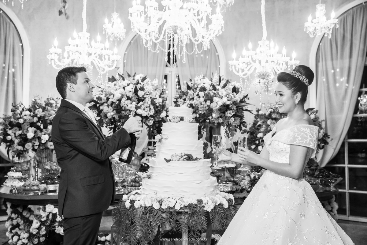 O casal abrindo o espumante para o brinde deles.