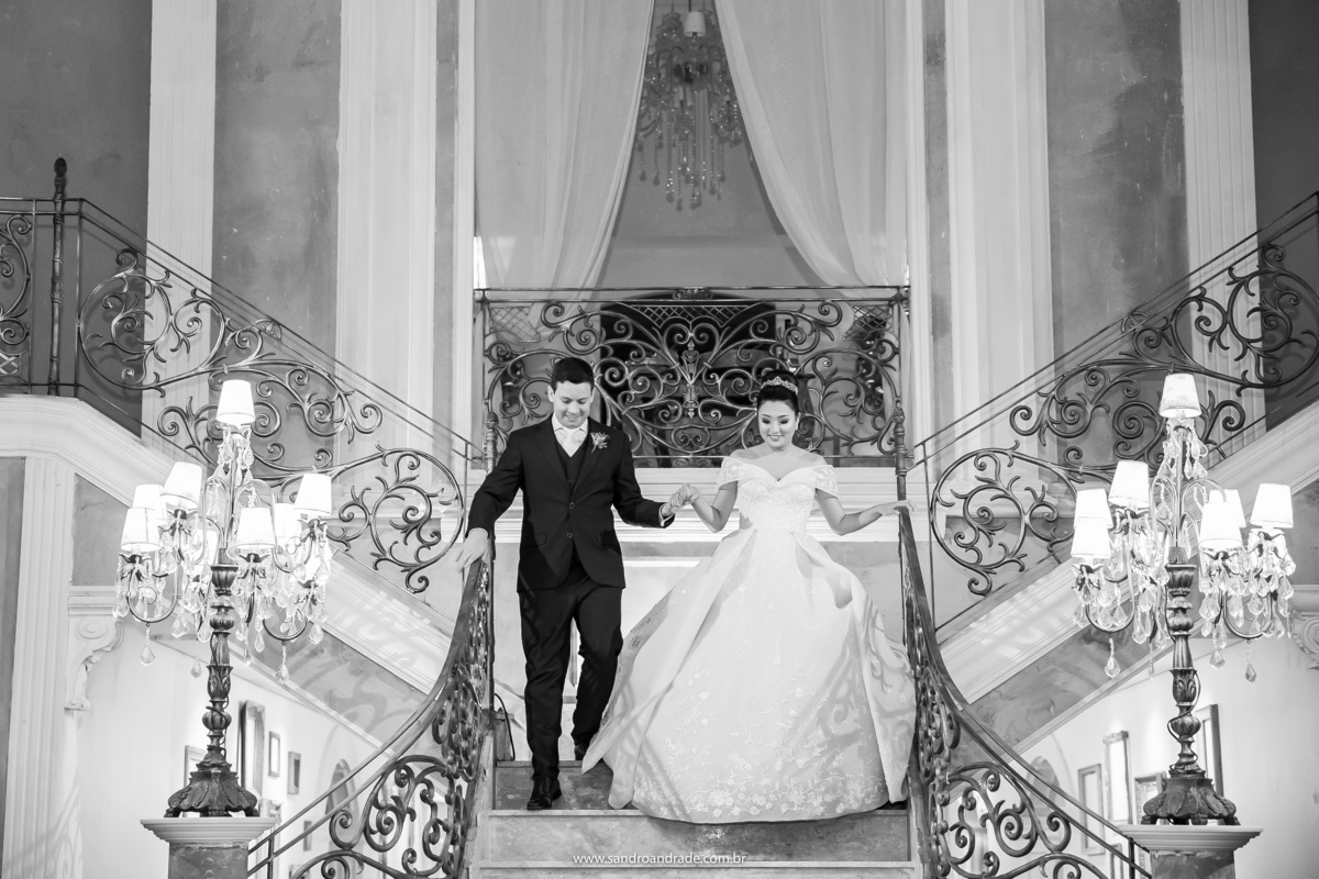 Chegada do casal na festa de casamento, eles estão descendo as escadas de mãos dadas, felizes e empolgados para a festa.