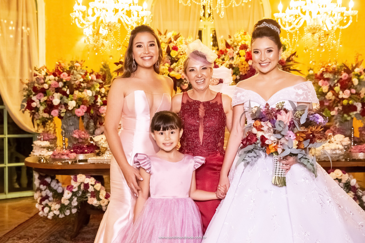 Dany com as irmãs e a mãe na mesa do bolo para as fotos protocolares.