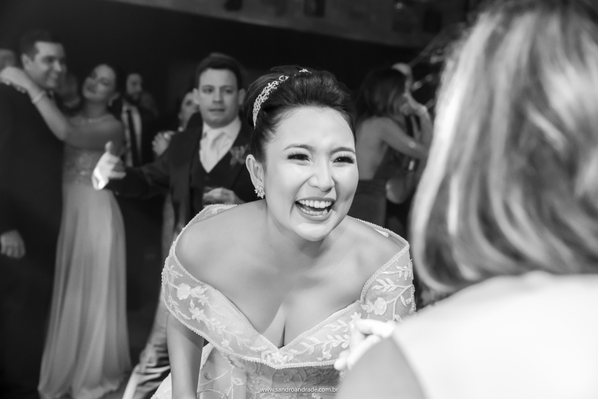 um retrato da noiva, muita feliz dançando com sua amiga.