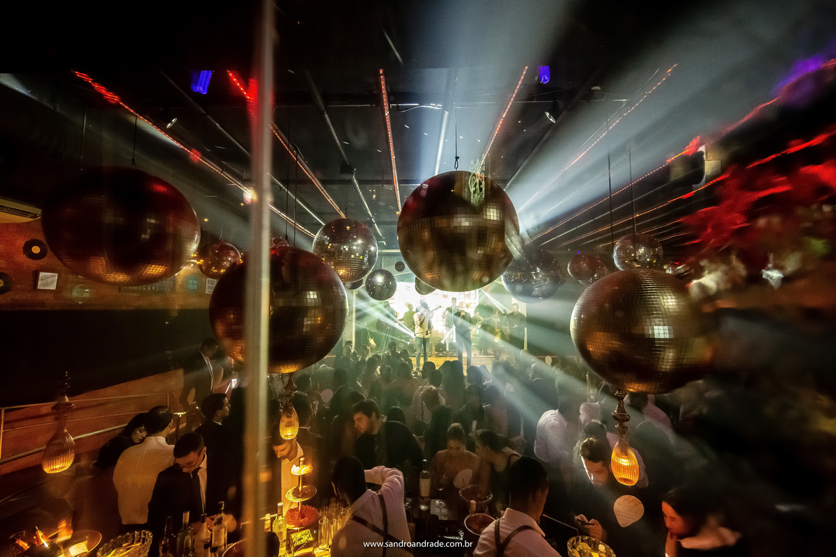 Fotografia da boate toda, com a banda e todos os convidados se divertindo junto com o casal.