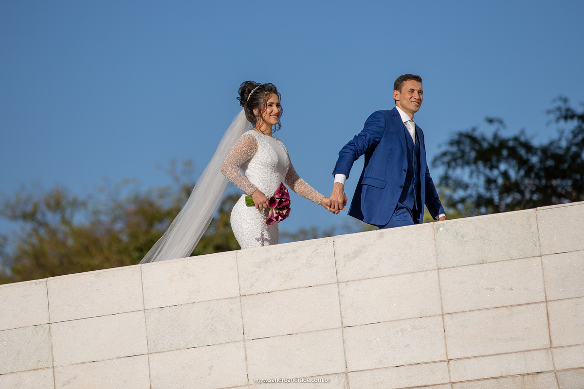 Mayara e Wedson estão subindo a rampa do panteão de mãos dadas, fotografia com luz natural.
