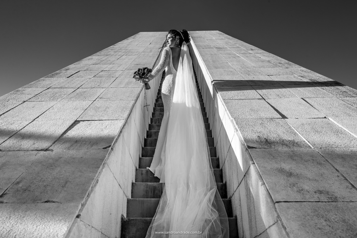 Um dos melhores fotógrafos de casamento Brasilia, Sandro Andrade é apaixonados pela arquitetura do lugar e quando a noiva diz que quer ser fotografada no plano, sempre amamos é  top das galáxias o resultado. A noiva na escadaria da Pira da pátria em pb.