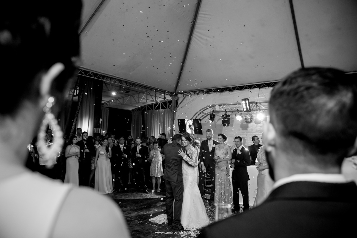 Os noivos estão dançando agarradinhos, abrindo a pista de dança.