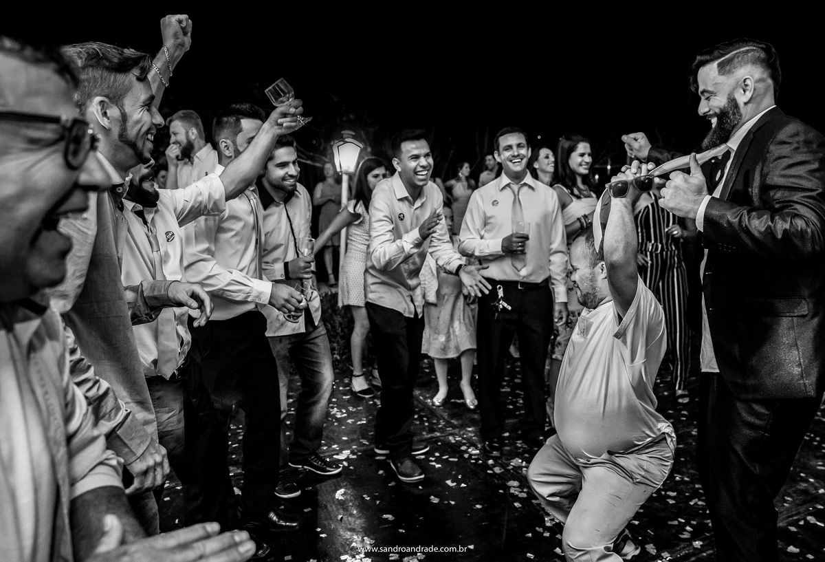 O padrinho na pista de dança, arrasando com um convidado, indo até o chão.