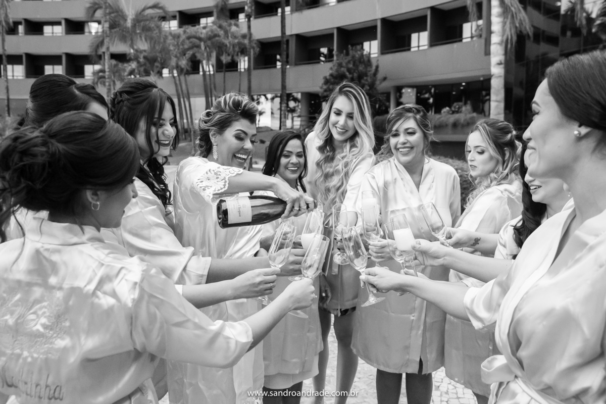 Wanessa está servindo espumante as madrinhas, uma bela fotografia preto e branco, muito descontraída. Fotografia de momento feita por Sandro Andrade fotógrafo de casamentos em Brasília.