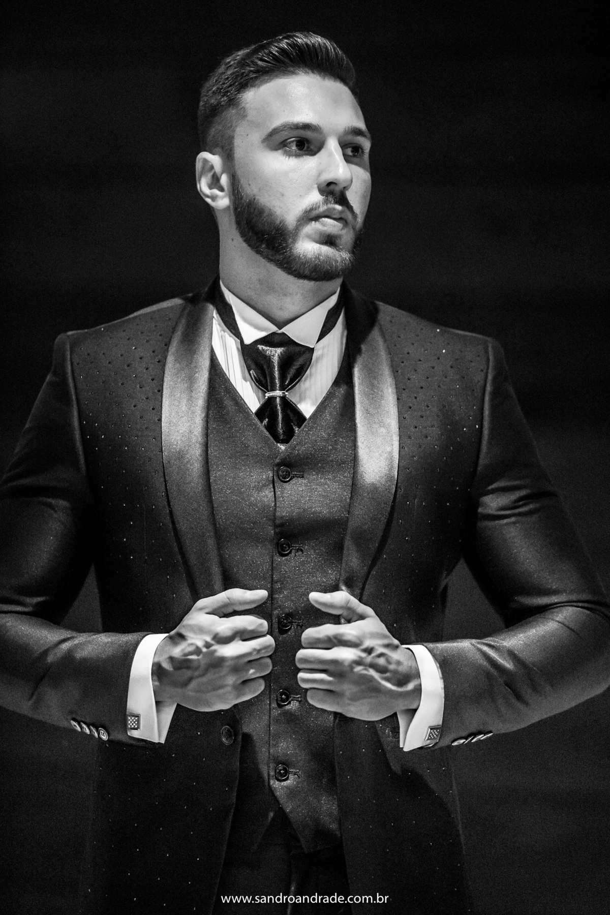 Retrato do noivo em preto e branco, posando para fotos com um lindo terno da M. Zanirato.