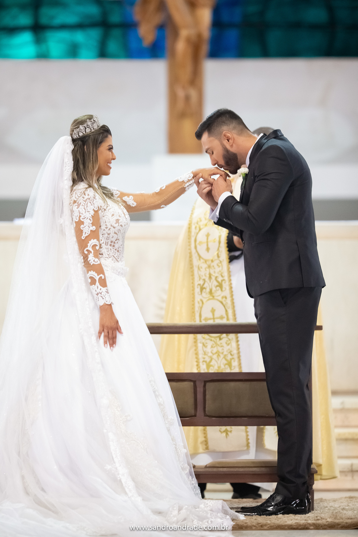 Mais um detalhe, Sandro beija a mão de sua noiva após colocar a aliança nela, tudo sob o olhar atencioso de um fotografo de Brasilia, Sandro Andrade.