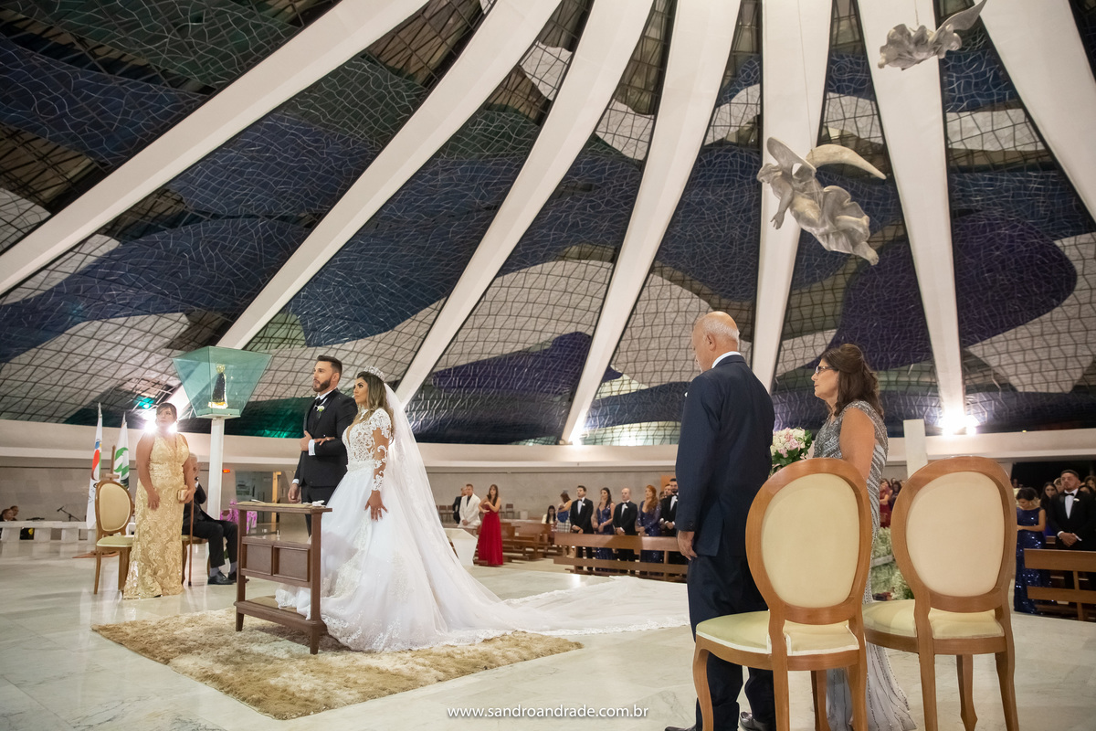 No altar e com os pais dos lados, Sandro e Wanessa recebem a benção final.