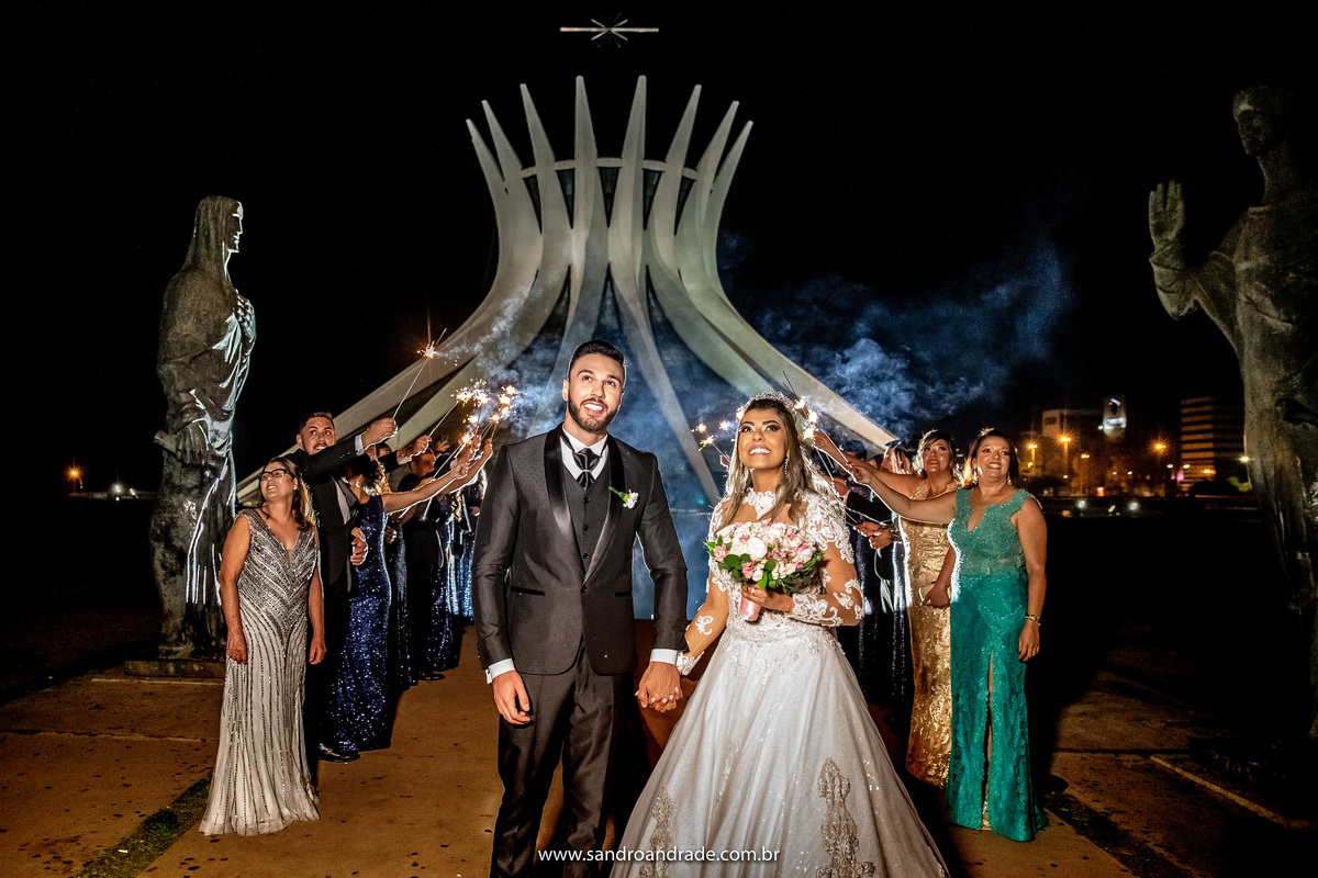 Os noivos estão olhando para o céu, vendo a linda queima de fogos.