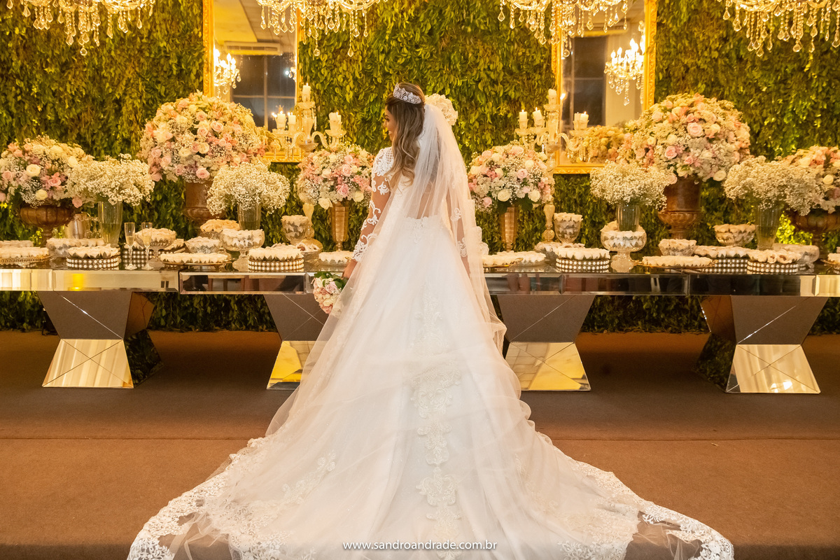 Aquela foto tradicional da noiva, colorida, na mesa do bolo, de costas com a cauda e véu arrumados.