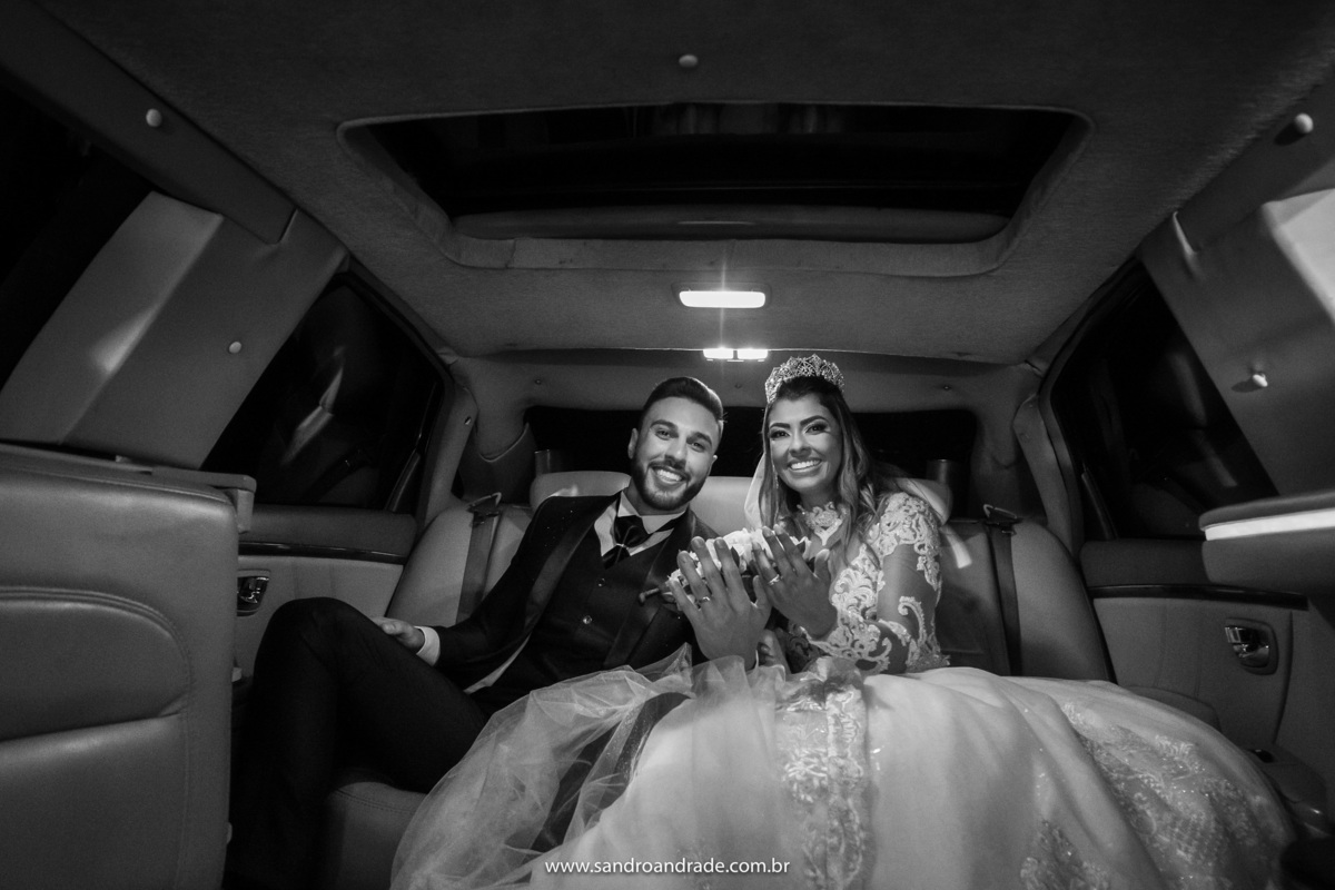 Sorrindo eles posam para a foto mostrando suas alianças.