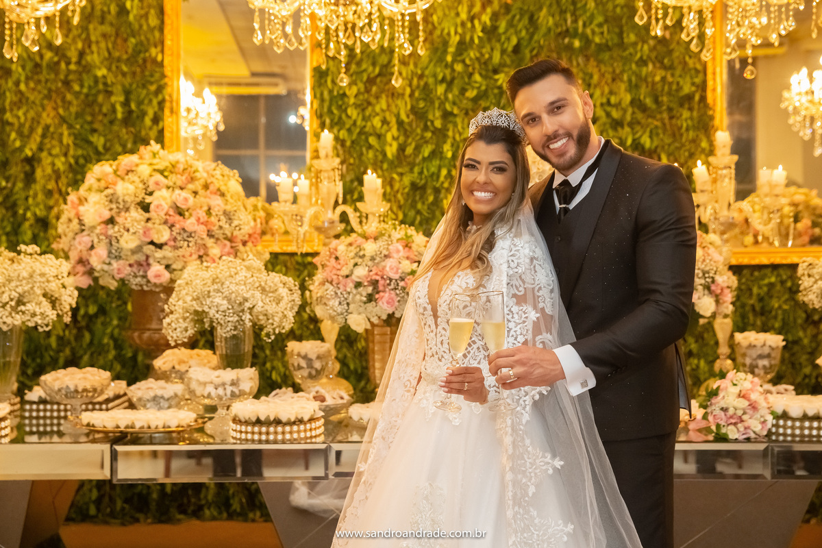 Chegou o momento das fotografias protocolares na mesa dos bolo, com o brinde o casal posa para fotos.